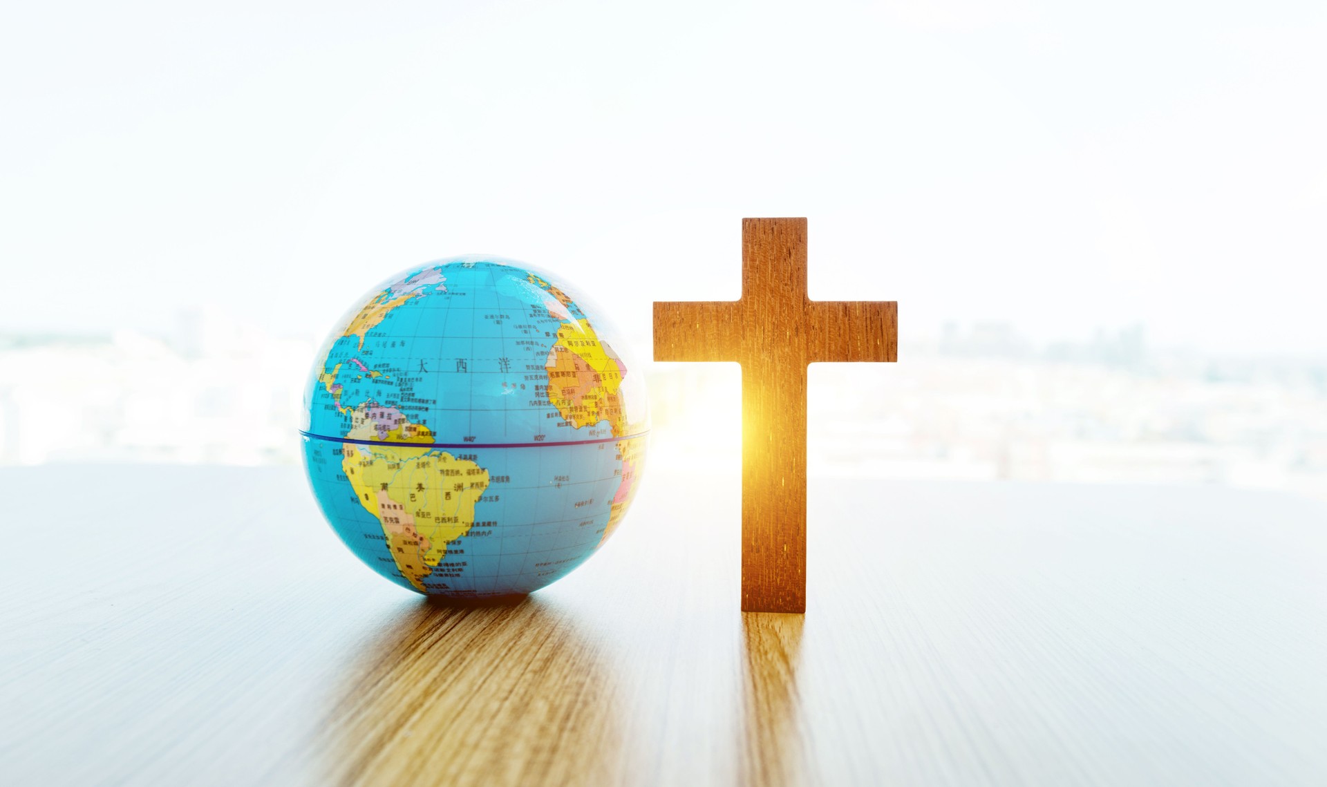 Earth globe and cross in table