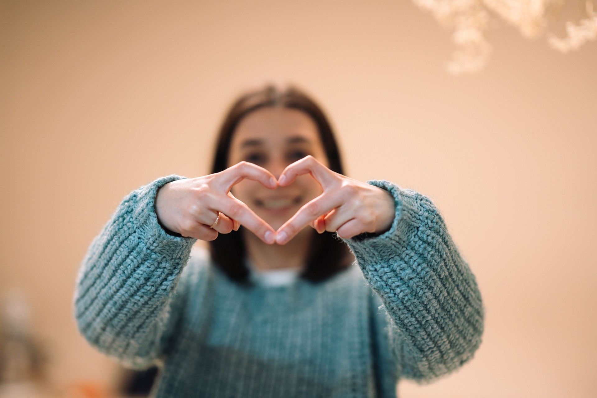 Young woman making heart shape with hands